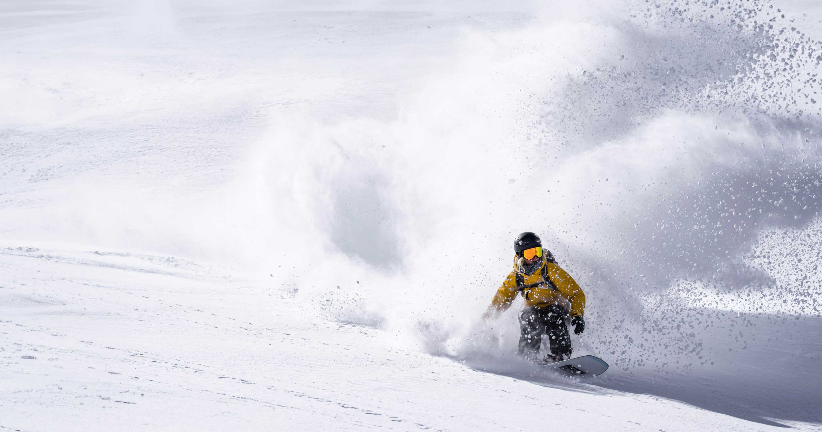 Amplid Snowboarder riding deep powder.